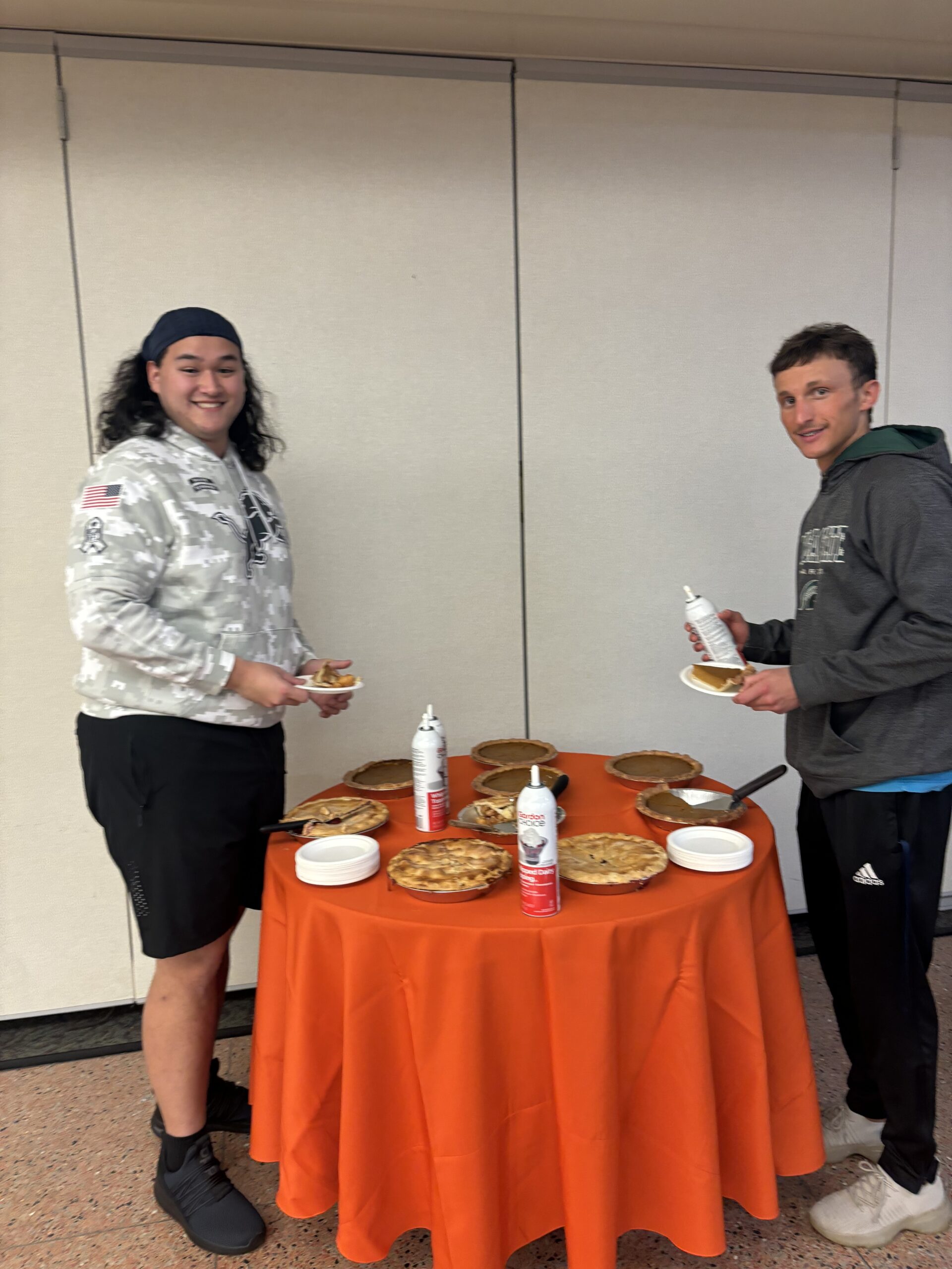 Two students at a pie table